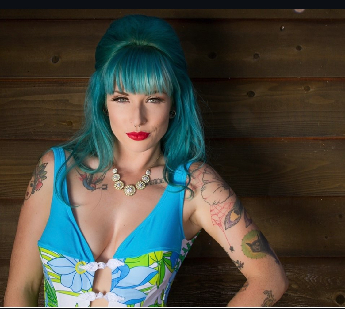 Vibrant teal-haired portrait with tattoos