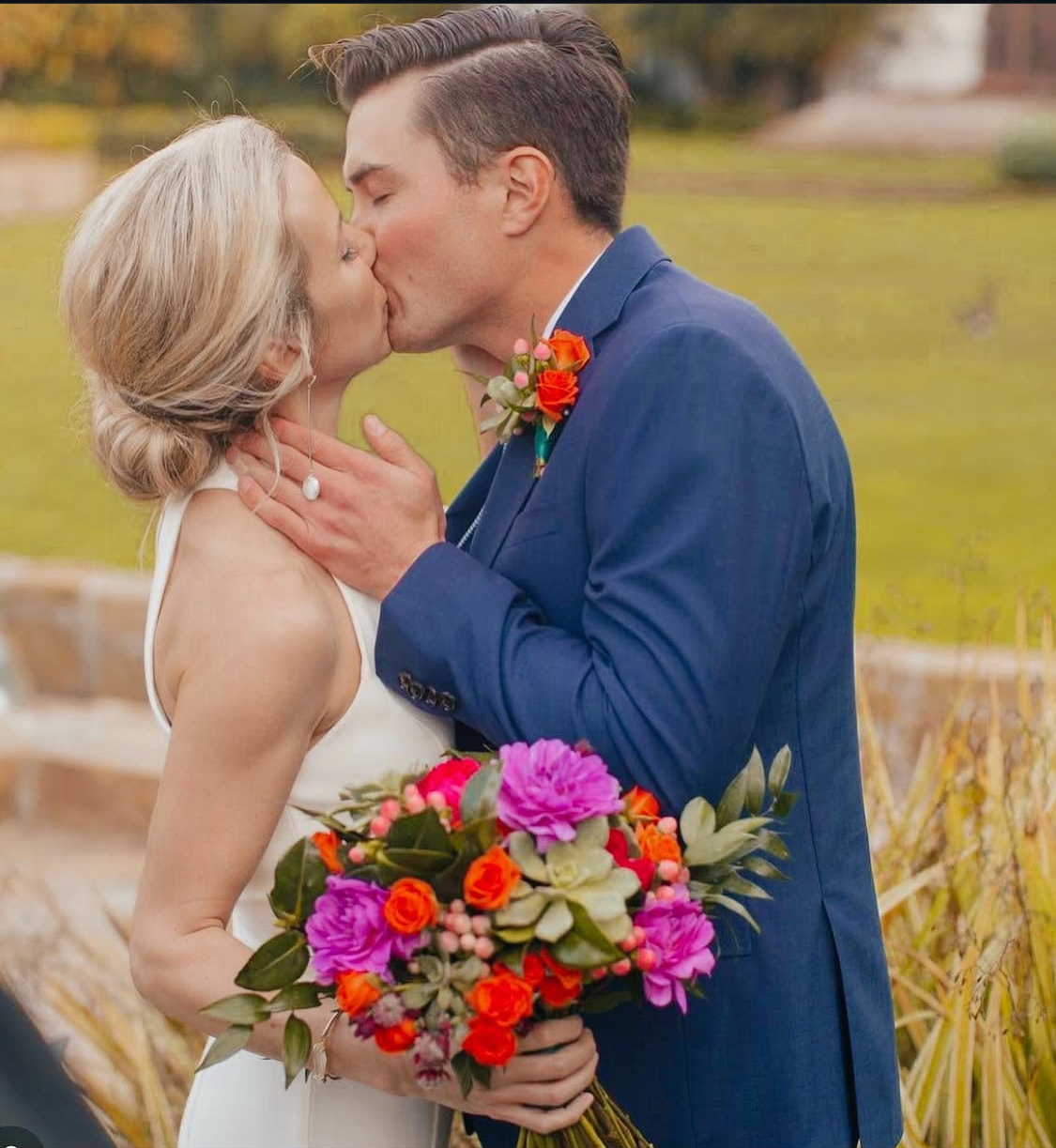 Wedding kiss with vivid bouquet