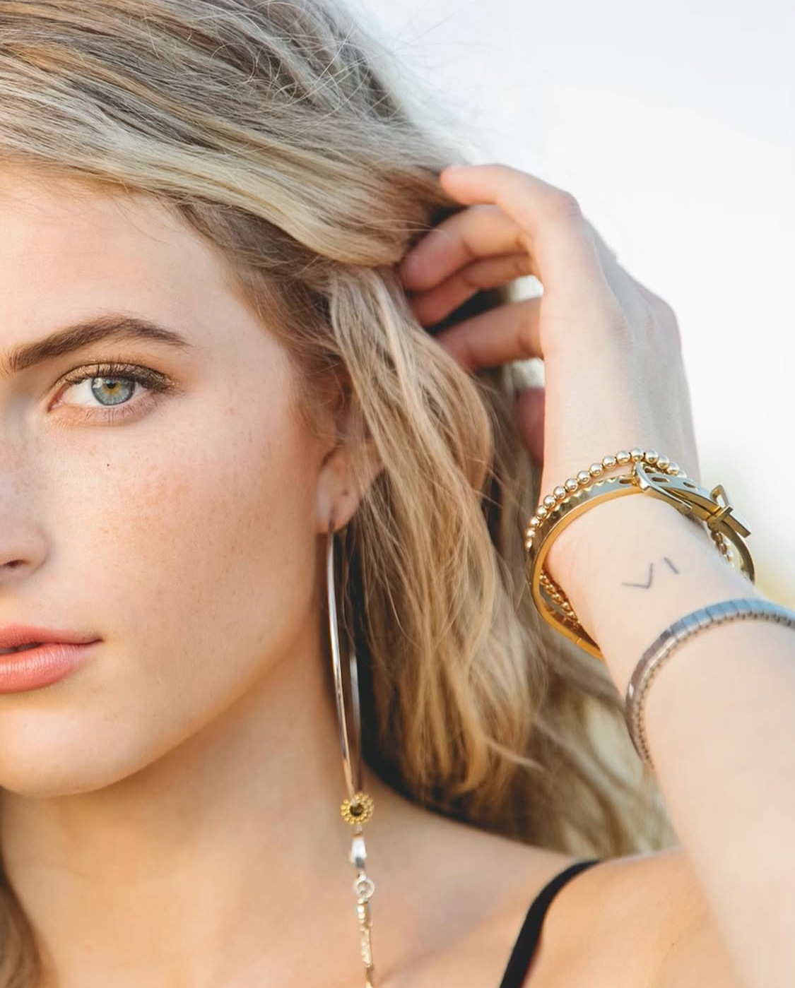 Close portrait with statement earrings and bracelets